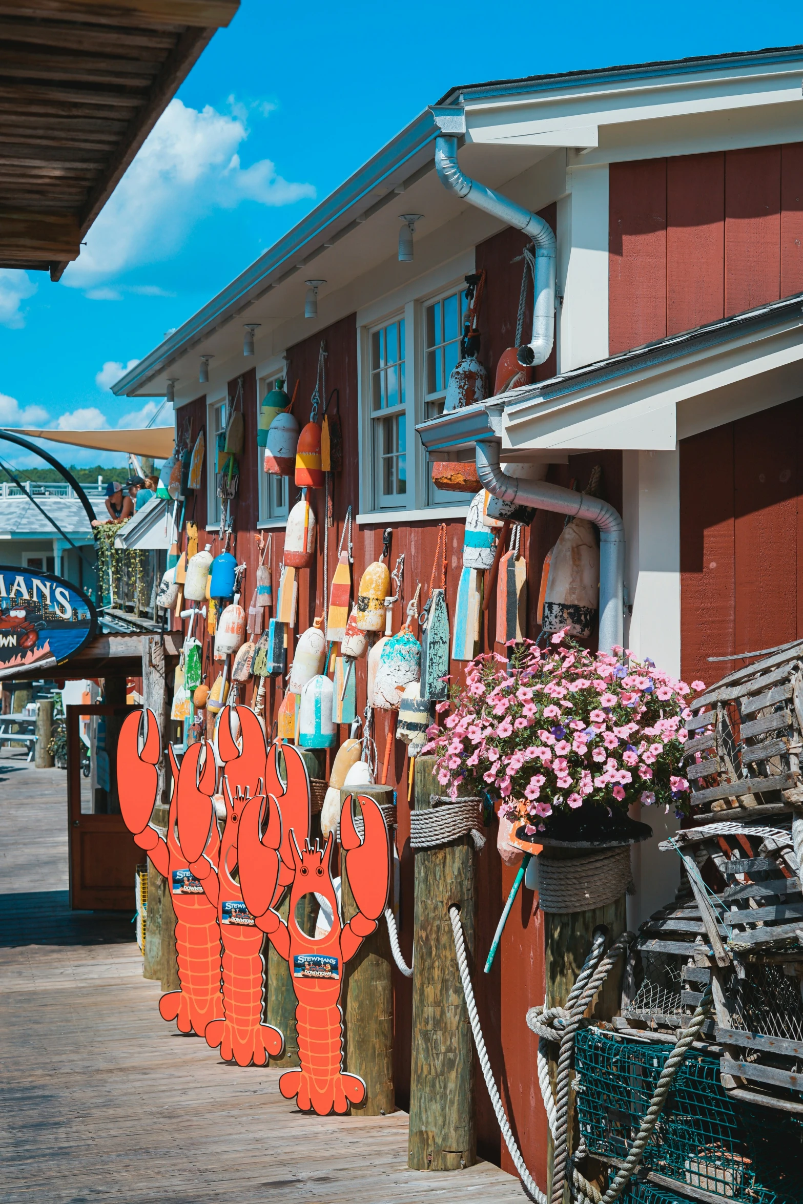 the front of a store with multiple lobster signs and some umbrellas