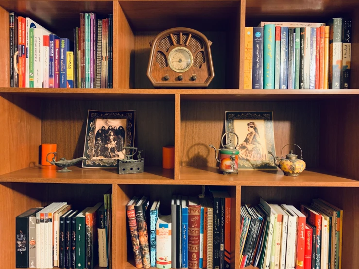 three shelves filled with various books and a clock