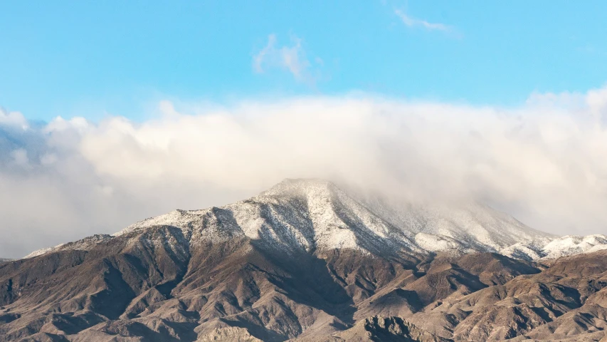 clouds over some mountains under a blue sky