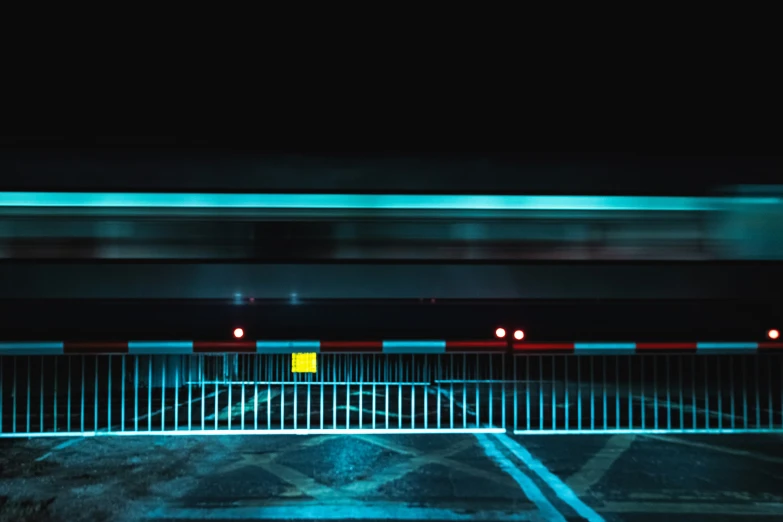 an empty parking space with lights on and a fence around it