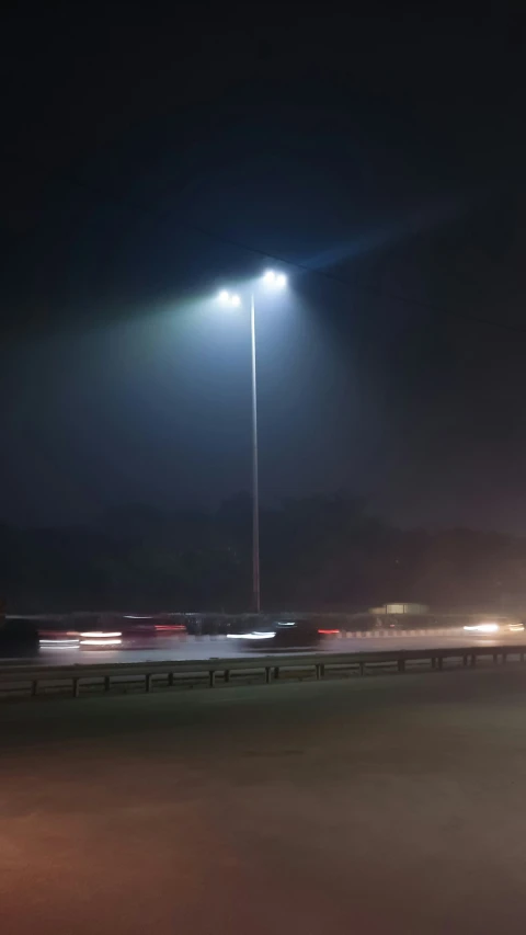 a bright street light on a snowy road at night