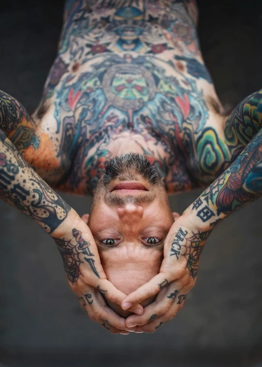 a man with tattoos holding his hands in the middle