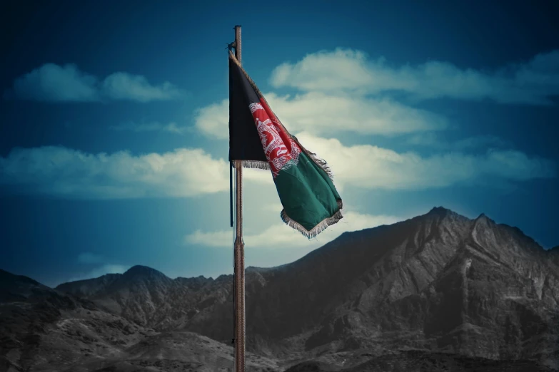 the united arab american flag is waving in front of a mountain range