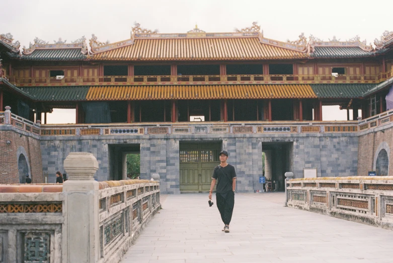 a woman wearing a long black dress is walking on the pavement