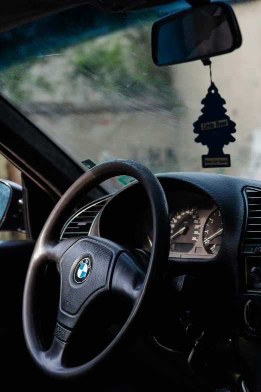 a dashboard of a car with a clock hanging from it