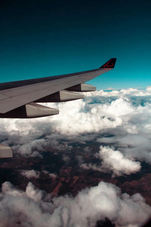 the wing of an airplane is in view above the clouds