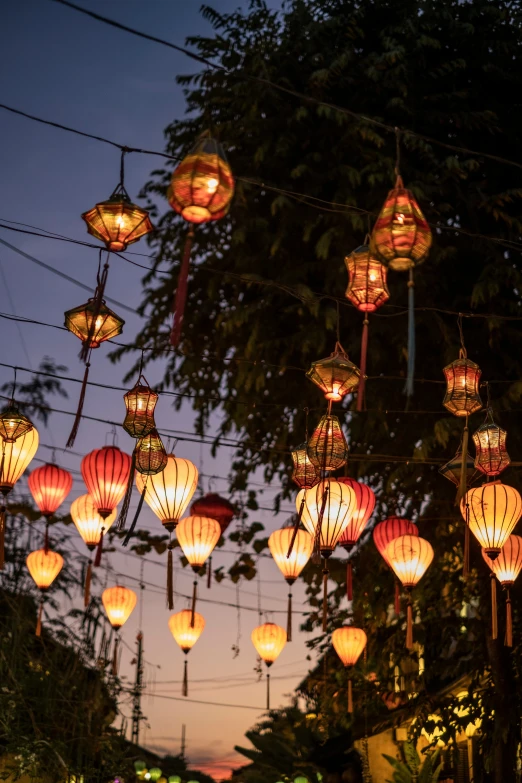 lots of lanterns that are hanging from the street