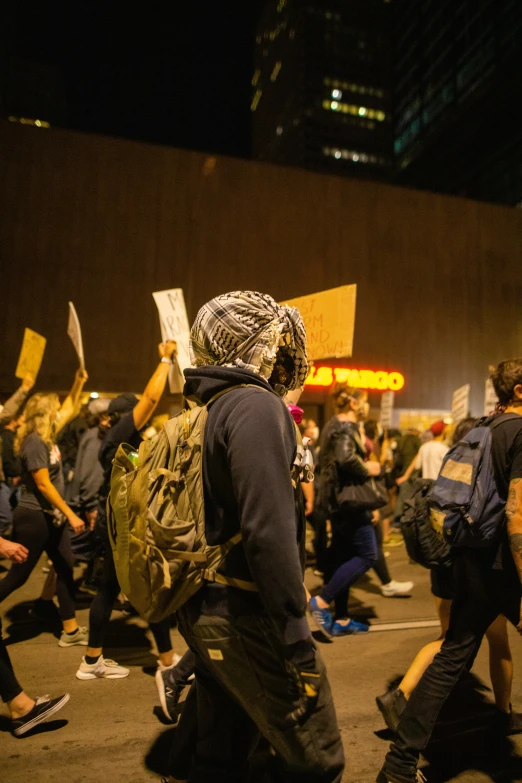 a group of people with backpacks are walking away from a sign