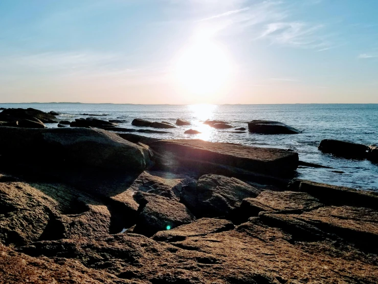 a sun that is shining through the sky over some water