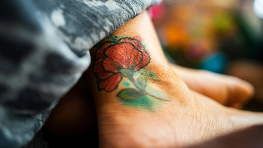 an arm tattoo with flowers on it