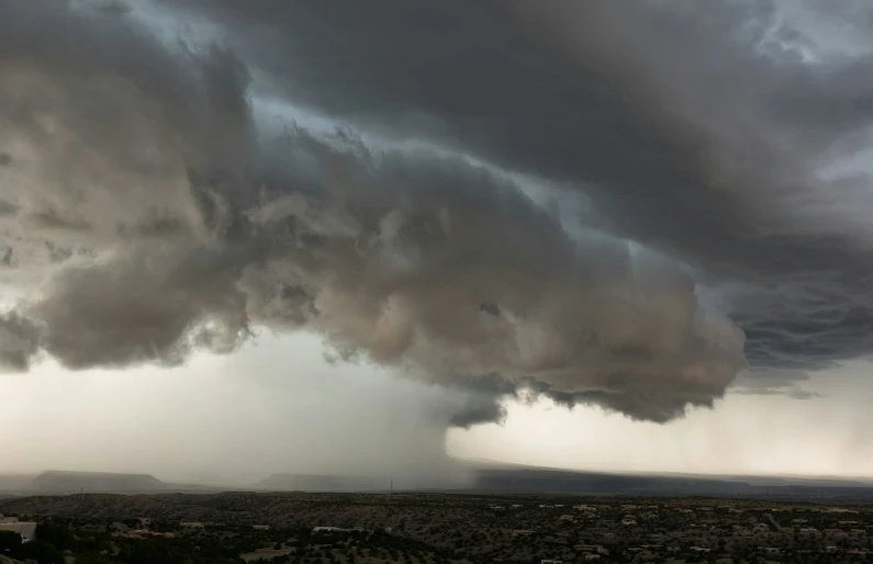 an ominous sky shows heavy white clouds over a city