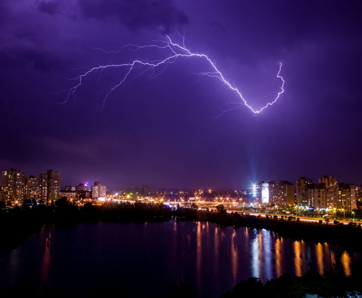 lightning over a city and lake in the distance