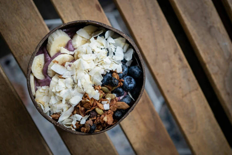 a small bowl of fruit and granola sitting on top of a wooden table