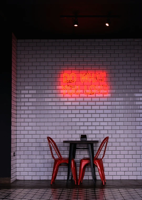 two chairs sitting under a table near a wall