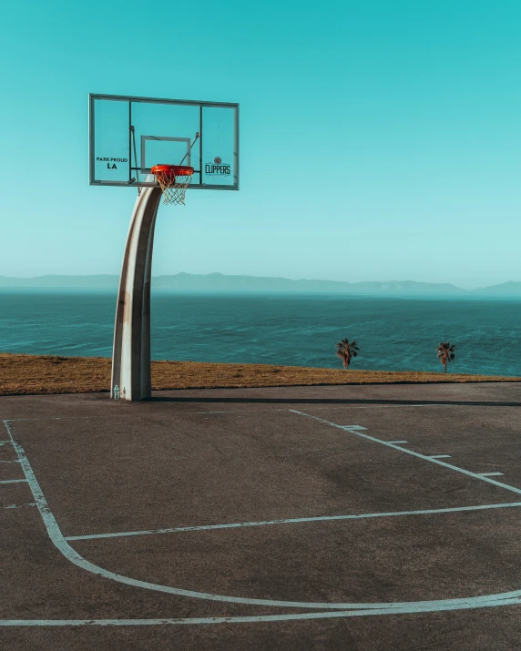 a basketball court with the ocean in the background