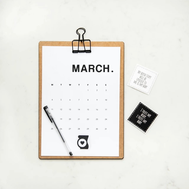 an open march calendar on a clipboard and stamp