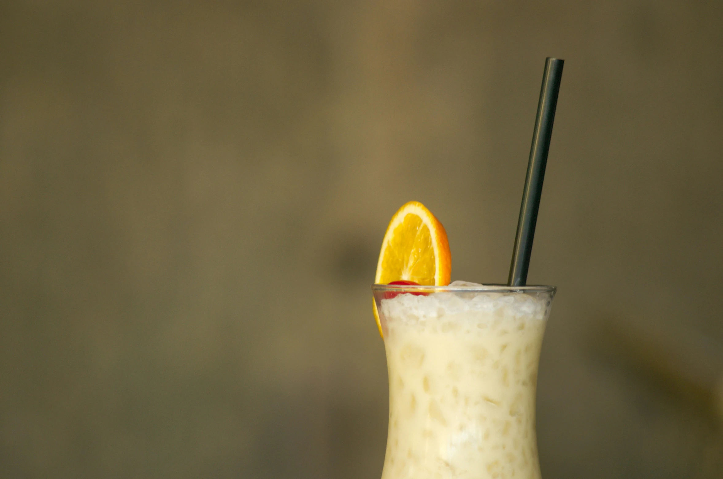 an orange slice is next to a drink with a straw