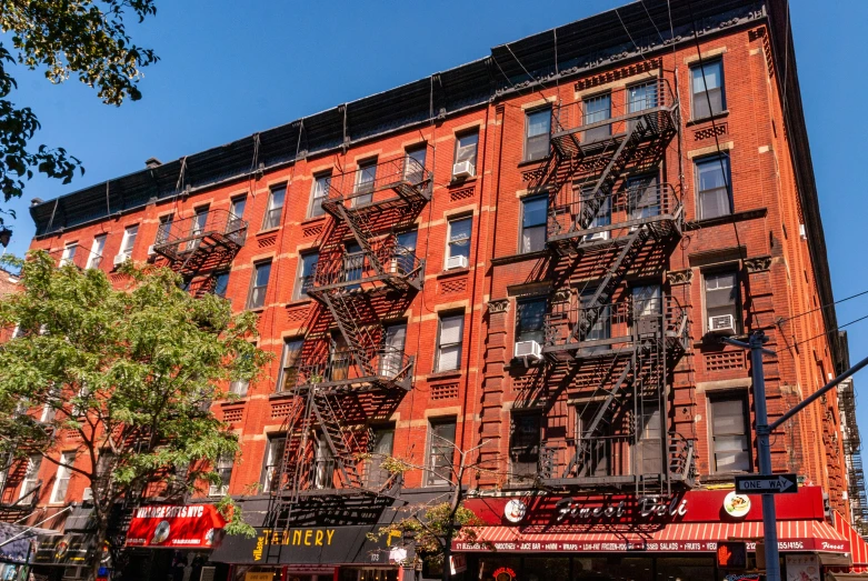 an orange building with many windows next to a street