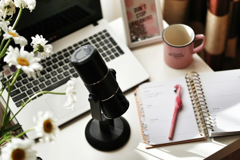 a cup of coffee and a camera sitting on a desk next to a laptop