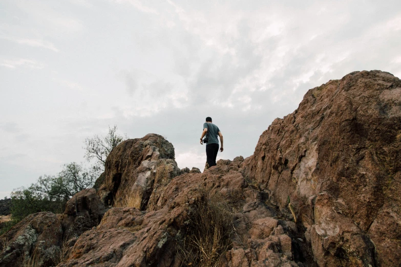 a person stands on top of a rock near the clouds