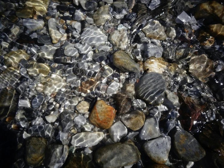 water on a beach with rocks and pebbles