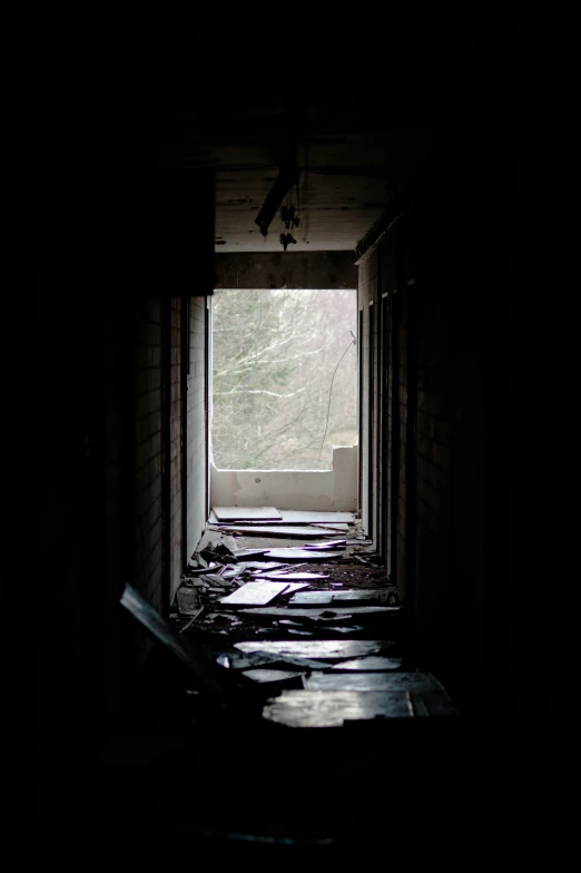 some wooden benches in an alley with a light at the end