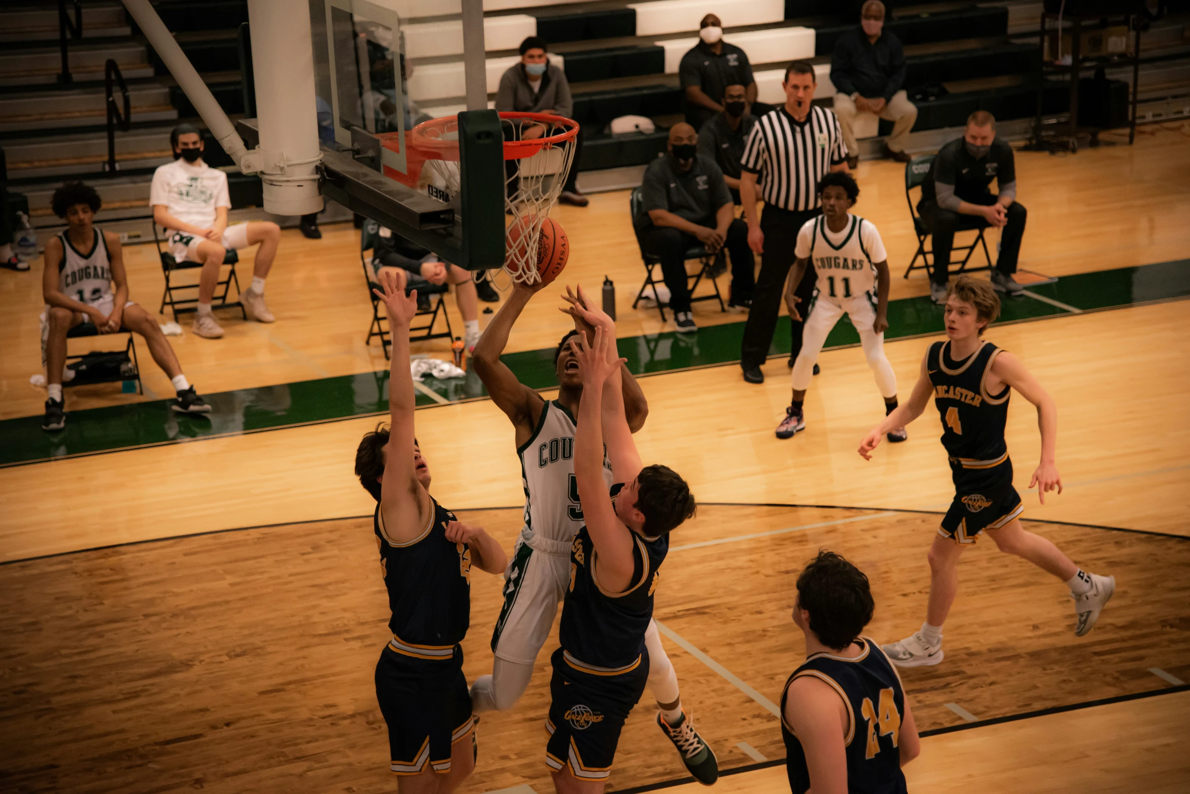 several young men on basketball teams are playing basketball