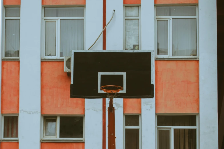 basketball hoop in front of a very orange and white building