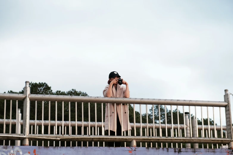 the woman taking pictures from the top of a bridge
