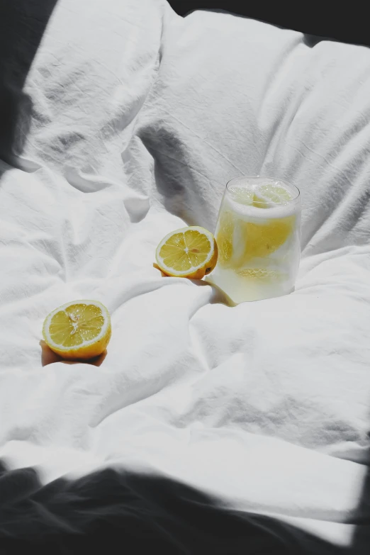 a glass of lemonade sits on a bed