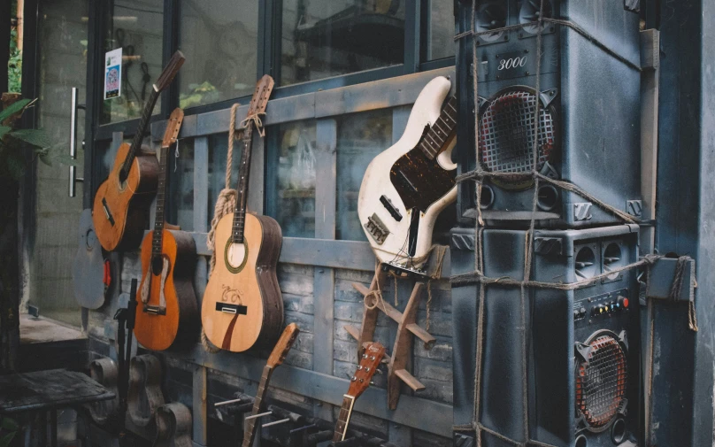 many guitars are placed on the rack and hanging