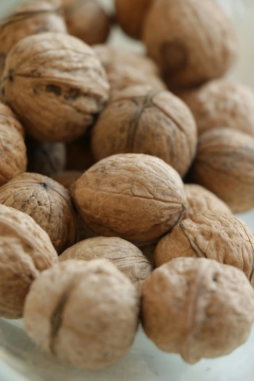 many walnuts are in a bowl with some nuts