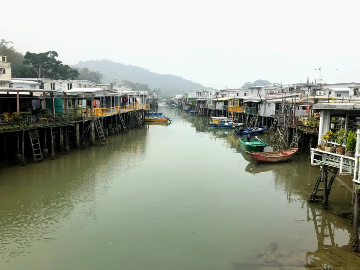 a waterway that has several small houses with a long rowboat