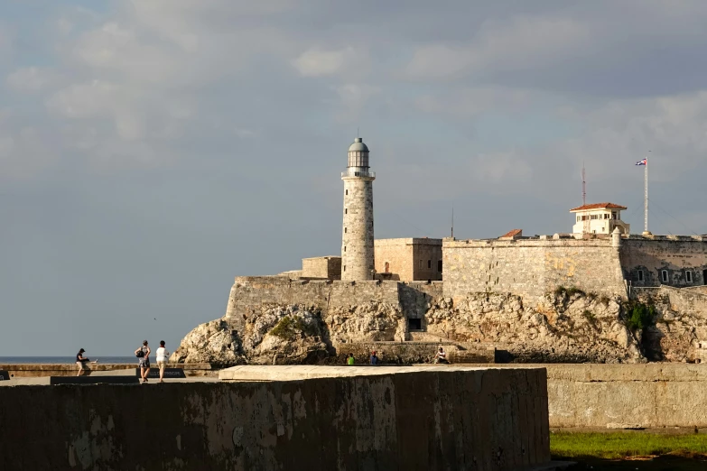 lighthouse on island with people standing at the end