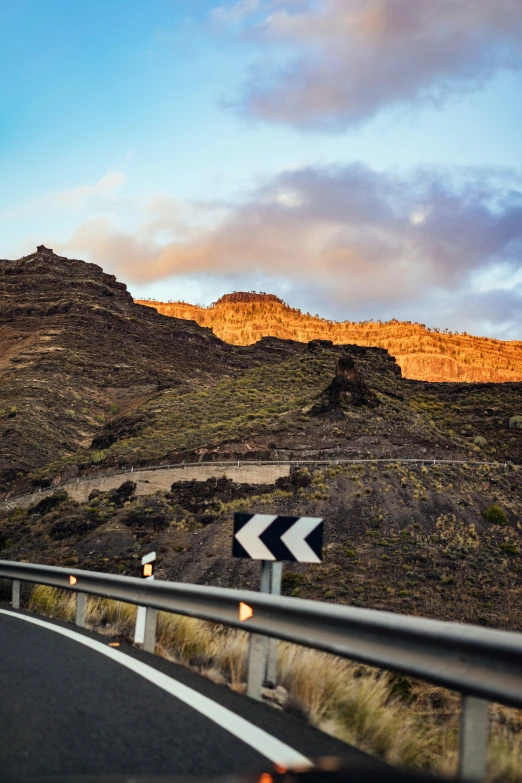 a curve in the road leading towards a distant mountain