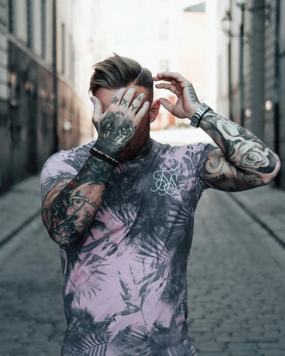 tattooed man standing in a street