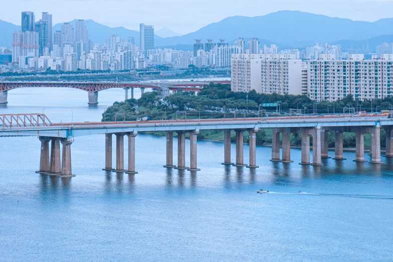 the train bridge crosses the river towards an overpass