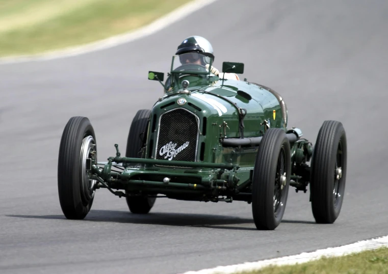 a green race car is shown driving down the track