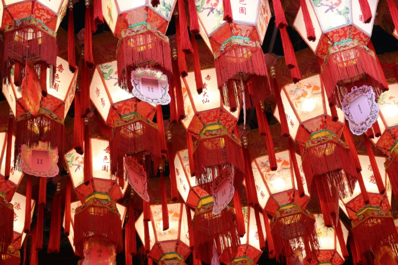 rows of red asian lanterns with oriental paper decorations hanging in a row