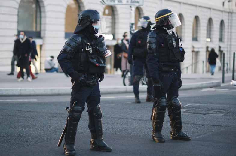 two police officers on street with people on building