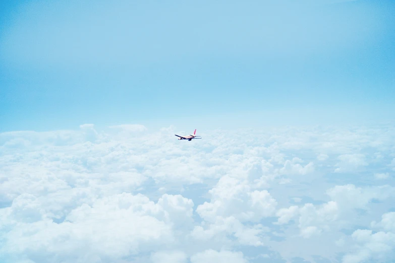 an airplane flying high in the sky above some clouds