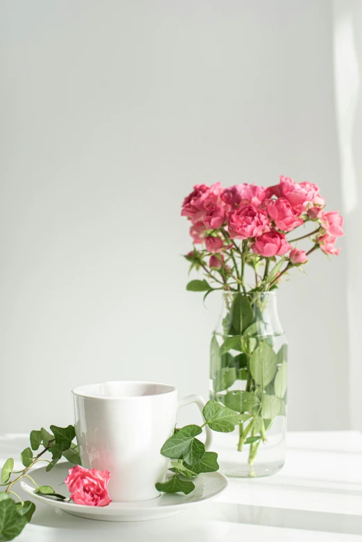 three cups on a plate, with a plant and flowers