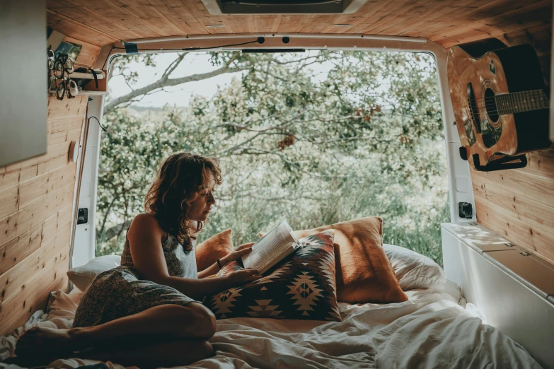 a person laying in bed next to a window