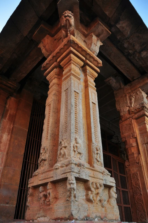 an ornate statue stands among tall columns with iron gates