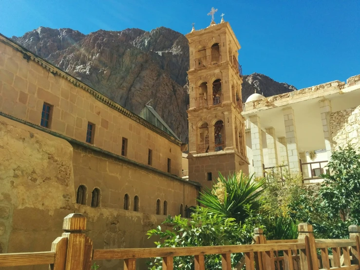 an old building with mountains behind it