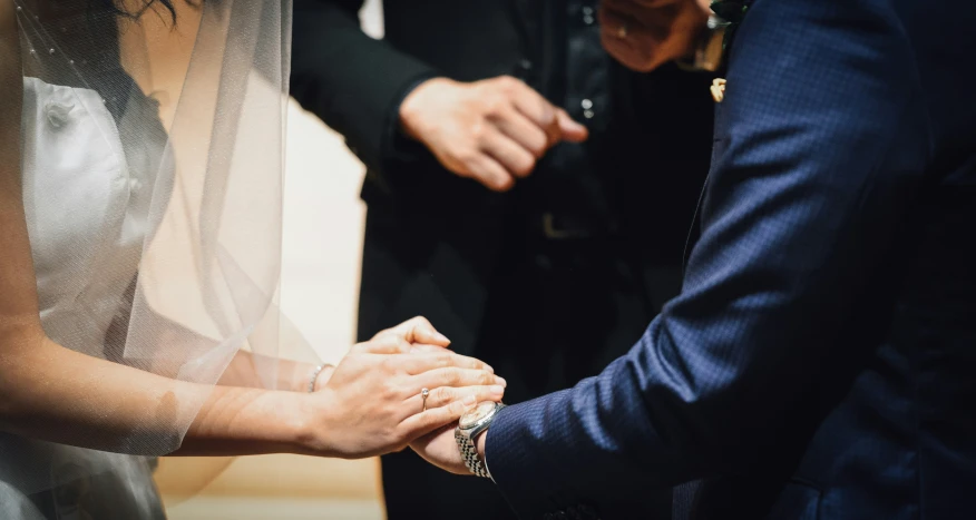 two people holding hands in the middle of the room