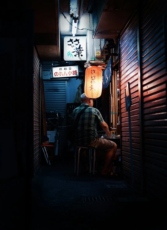 a man sitting on a chair in front of a doorway under lamps