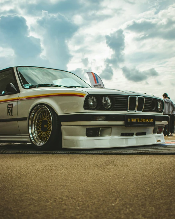 a bmw car with two people standing around it