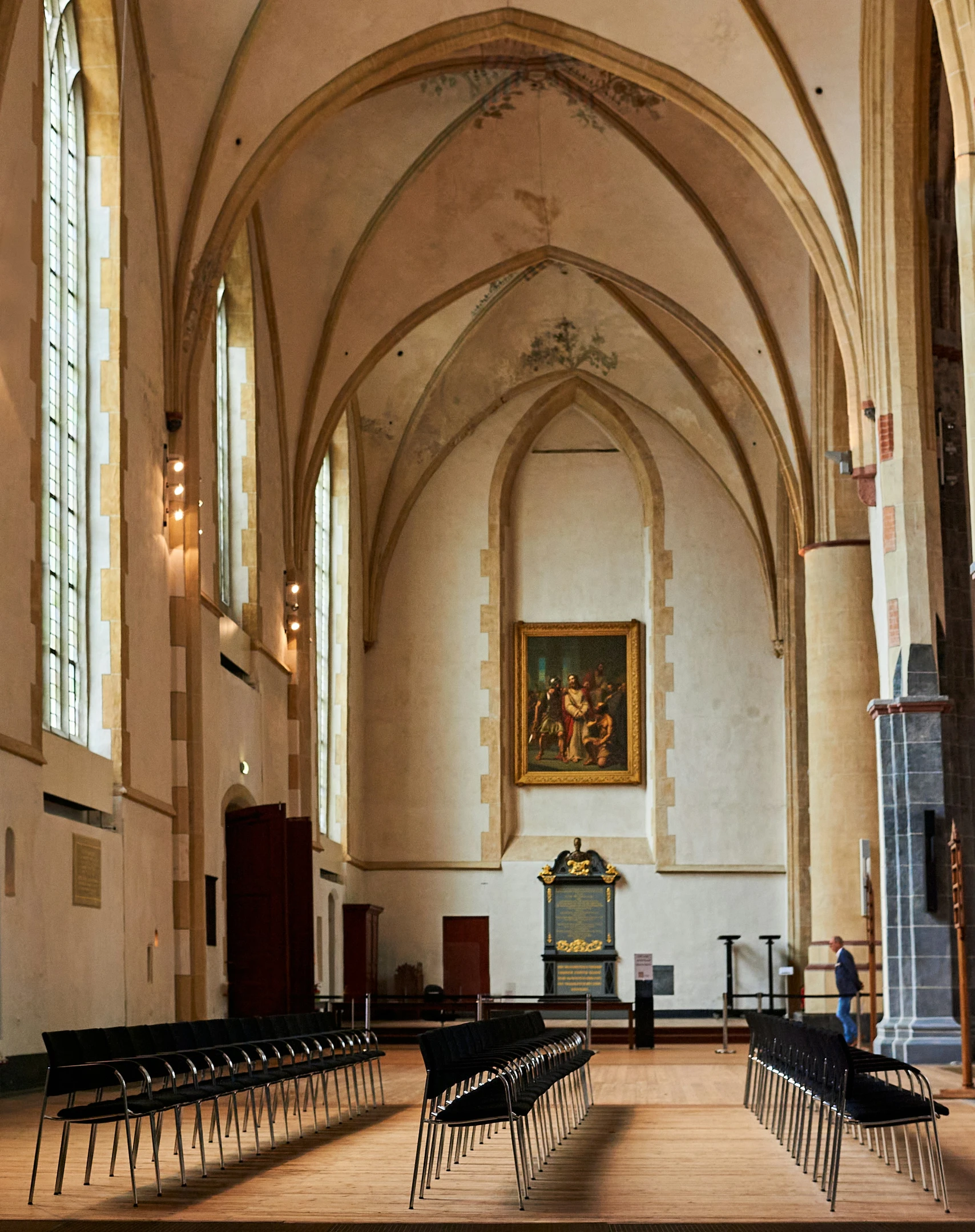 two men stand in an elaborate church with paintings on the walls