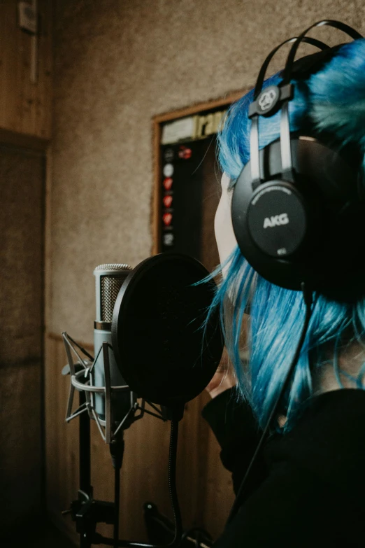 a person with blue hair with headphones on